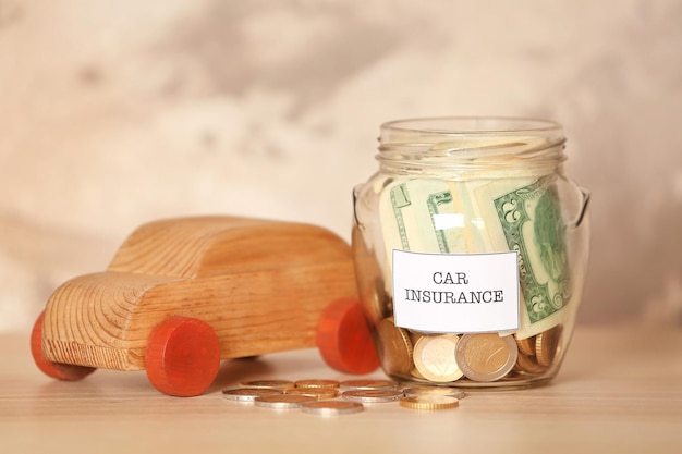 Photo glass jar with money and wooden car toy on table