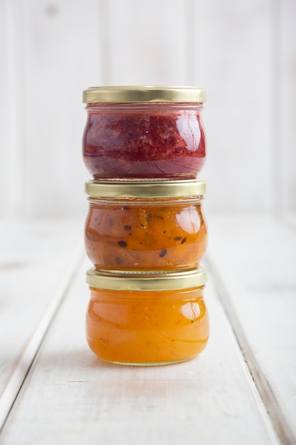 Glass jar with strawberry passion fruit and orange Jam jelly marmalade home made from fruits sugar