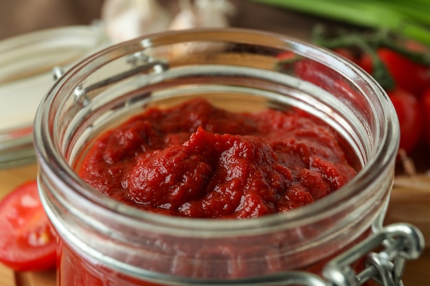 Glass jar with tasty tomato paste, close up