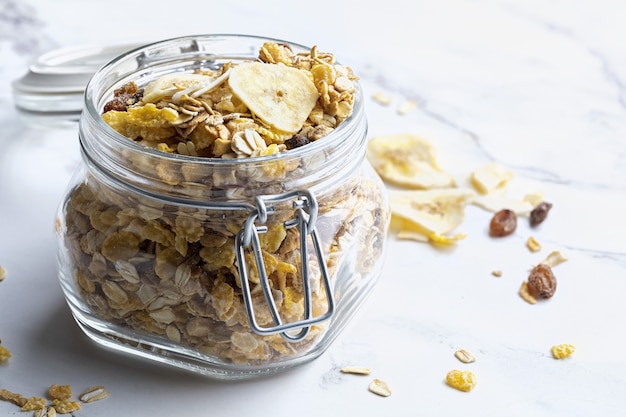 Glass jar with whole grains for breakfast. Muesli with dried fruits and dried fruits. With copy space.
