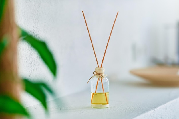 Glass jar with wooden aroma sticks in home interior