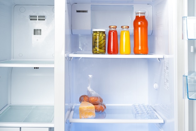 Glass jars of canned products on a fridge shelf