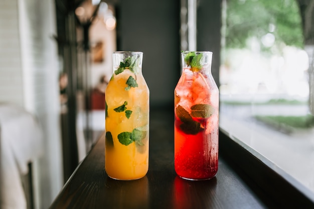 Glass jars fresh fruit lemonade on wooden table