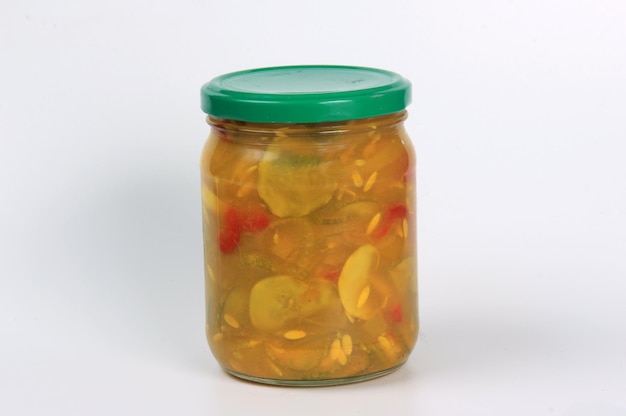 Glass jars with canned cucumber salad on a white background