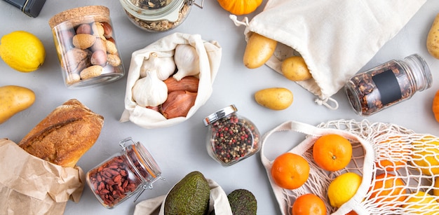 Glass jars with grains, reusable bags with fresh vegetables, fruits