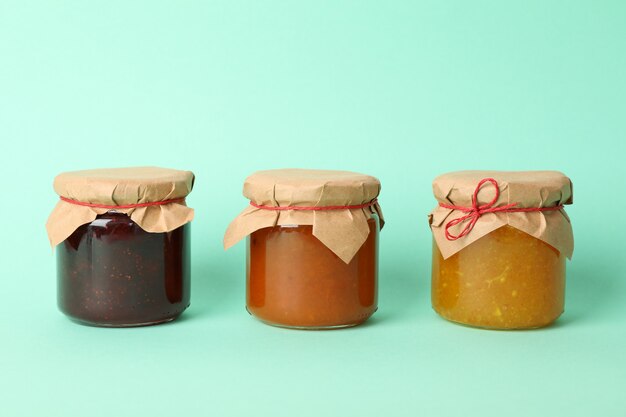 Glass jars with jam on mint, space for text