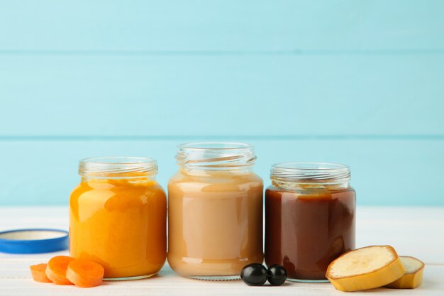 Glass jars with nutrient baby food in a row