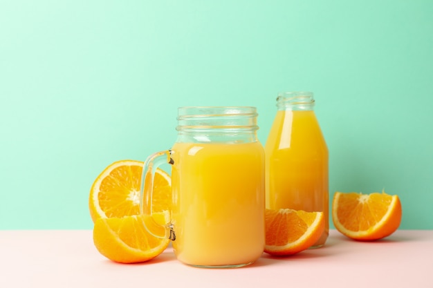 Glass jars with orange juice against mint