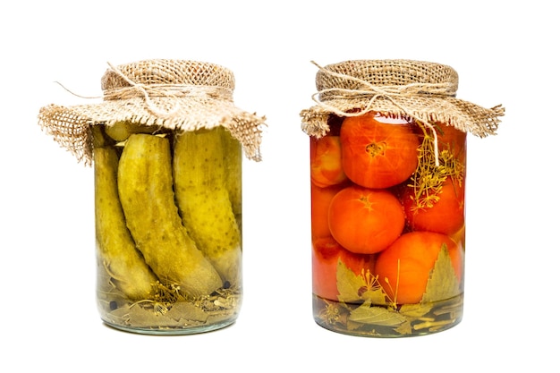 Glass jars with pickles and pickled tomatoes Traditional healthy preparations of food for the winter Isolated on white background