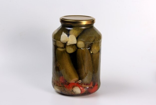 Glass jars with pickles on a wooden table. Canned cucumbers