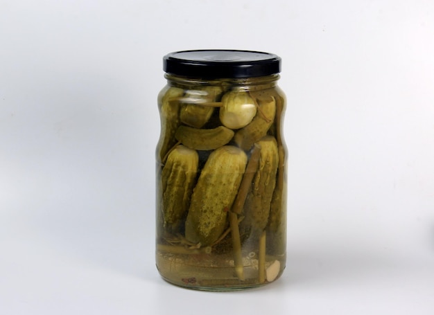 Glass jars with pickles on a wooden table. Canned cucumbers