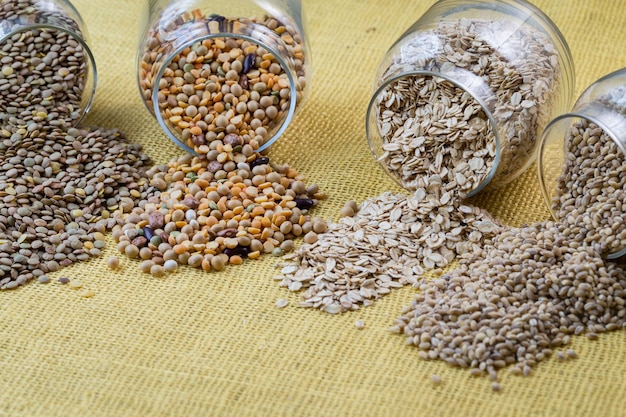 Glass jars with various legumes beans oatmeal flakes peas and lentils