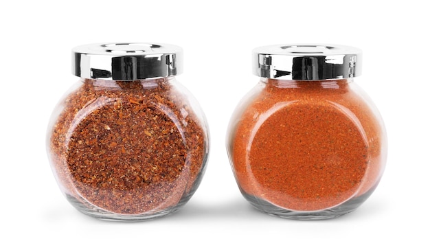 Glass jars with various spices flying on white background