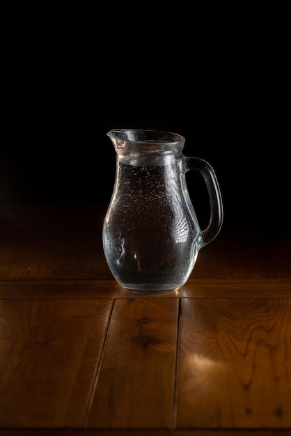 Glass jug with water on a dark background