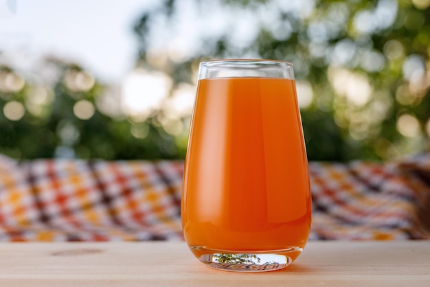 The glass of juice in a garden The wooden table