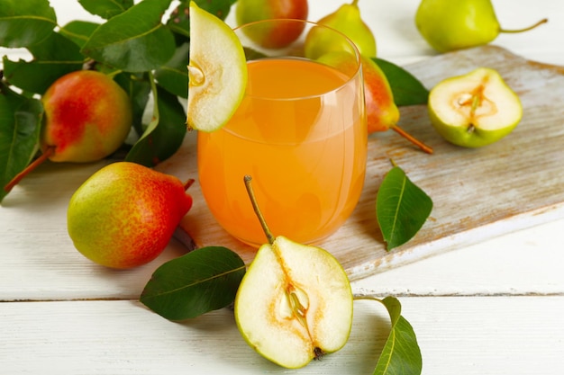 Glass of juice with fresh pears on wooden table closeup