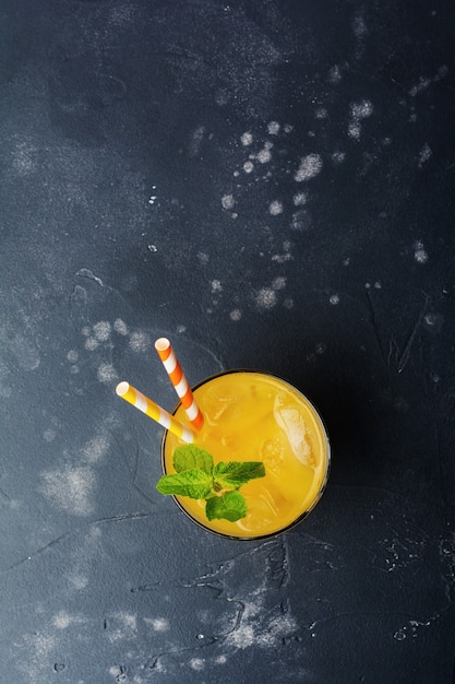 Glass of juice with mint leaves and ice dark old stone rustic