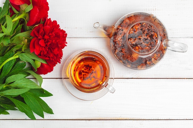 Стеклянный чайник из травяного чая со свежими цветами крупным планом