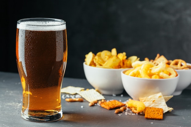 Glass of lager beer with snack bowls