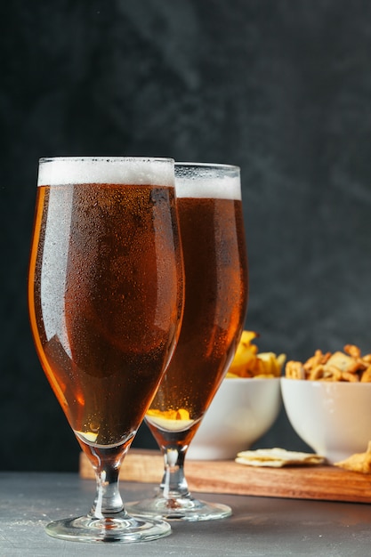 Glass of lager beer with snack bowls