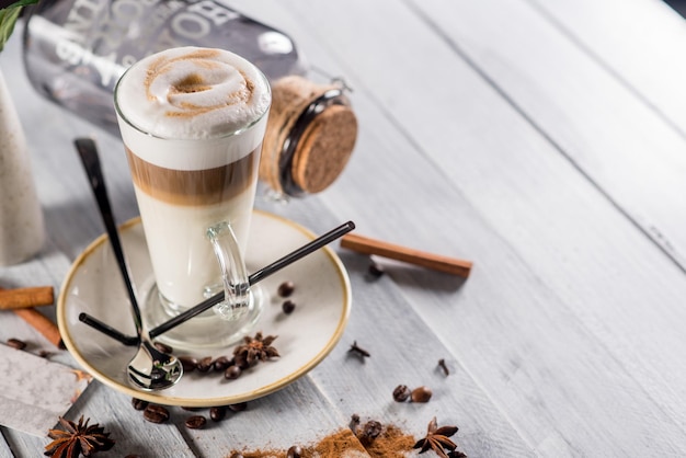 A glass of latte on the white wooden background