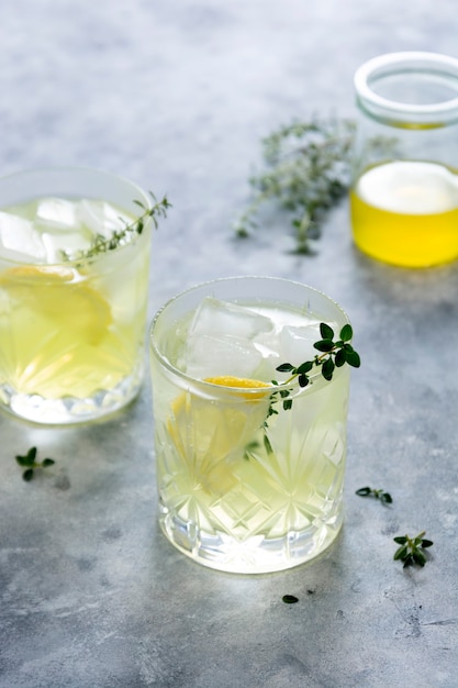 Glass of lemon fresh summer drink in glass. soda lemonade drink\
with herb.