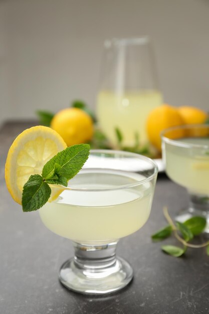 Glass of lemon juice with mint leaves on table