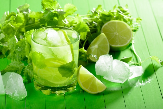 A glass of lemonade with lime and mint