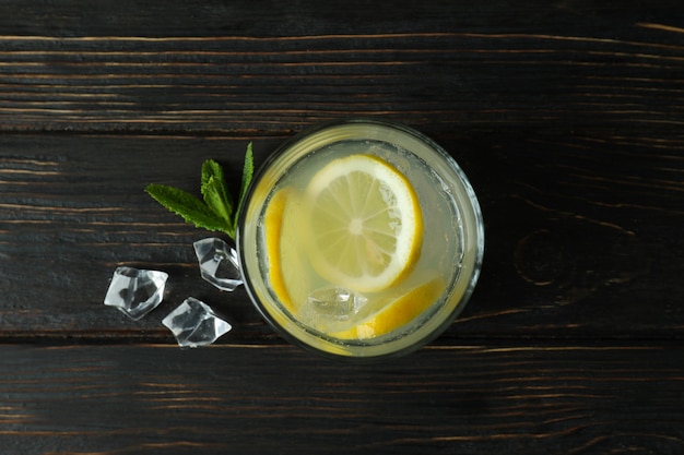 Glass of lemonade on wooden table, top view