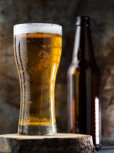 Foto un bicchiere di birra chiara su uno sfondo scuro