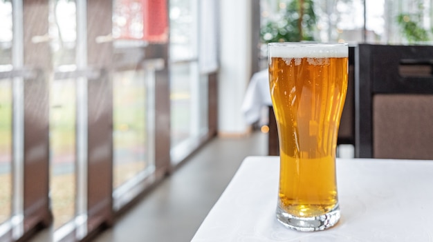 Glass of light beer on a table in a bar