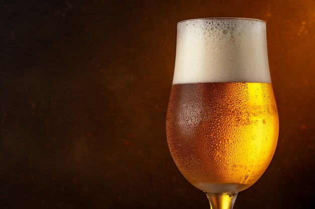 Glass of light beer on a wooden table.