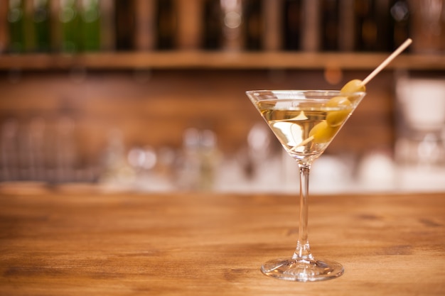 A glass of martini on the bar counter of a elegant restaurant. Cold drink. Tasty liqour.