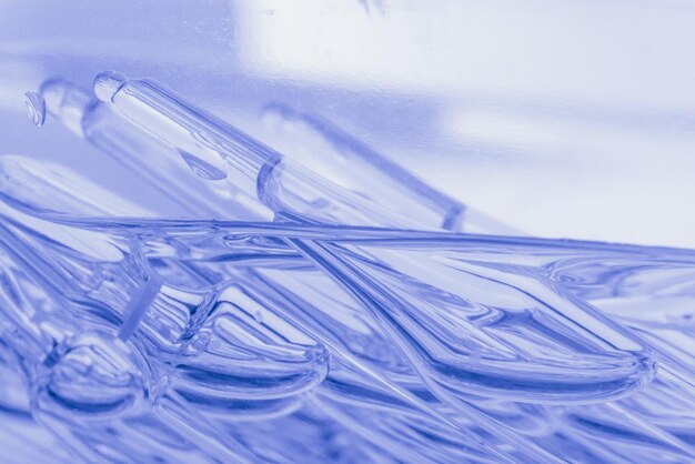 Стеклянная медицинская ампула для инъекций Медицина представляет собой жидкий хлорид натрия с водным раствором в ампуле Крупным планом Бутылки ампулы многоцветные на цветном фоне и воде Человеческая плазма