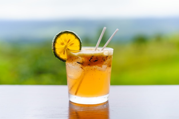 Glass of michelada with ice and lemon on the table in a jungle. Costa Rica gastronomy