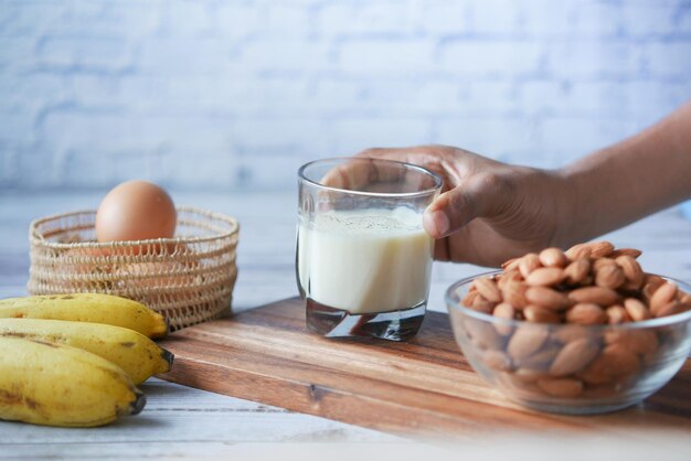 Glass of milk banana almond nut on table