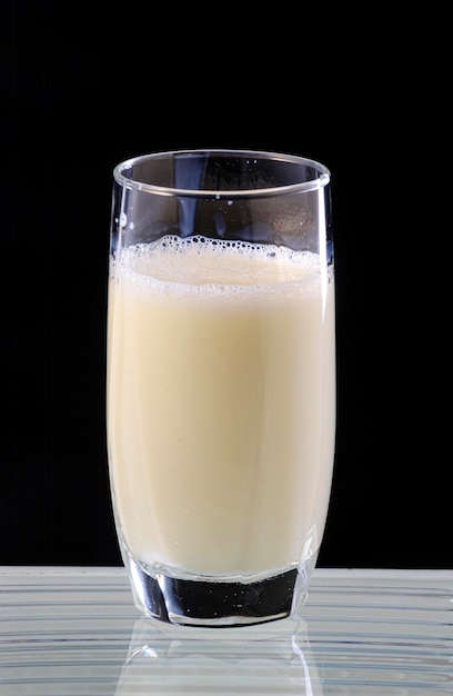 Glass of milk on black background