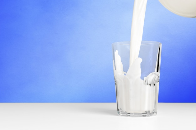 Photo glass of milk on blue background