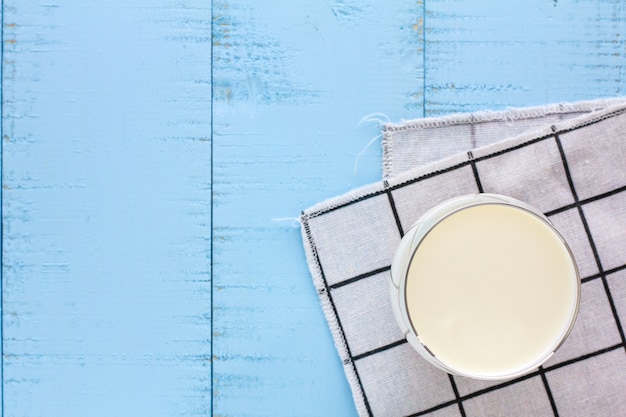 A glass of milk on blue wooden background.