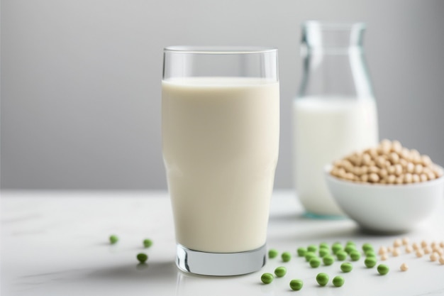 A glass of milk and a bowl of peas on a table.