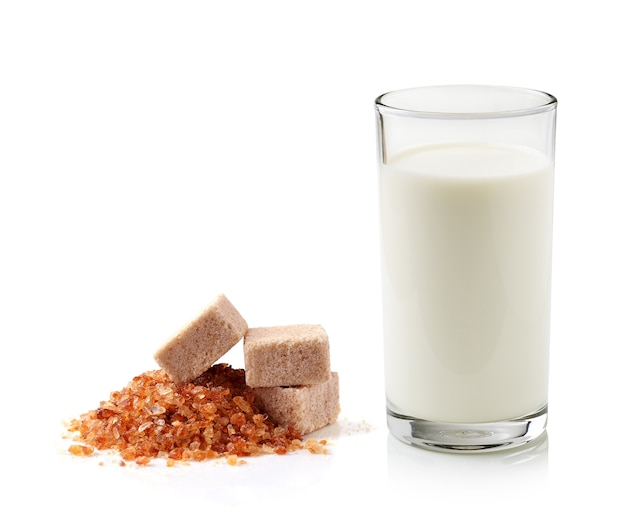 Glass of milk and cane sugar isolated on white background