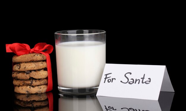 Glass of milk and cookies isolated on black