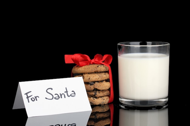 Foto bicchiere di latte e biscotti isolati su nero