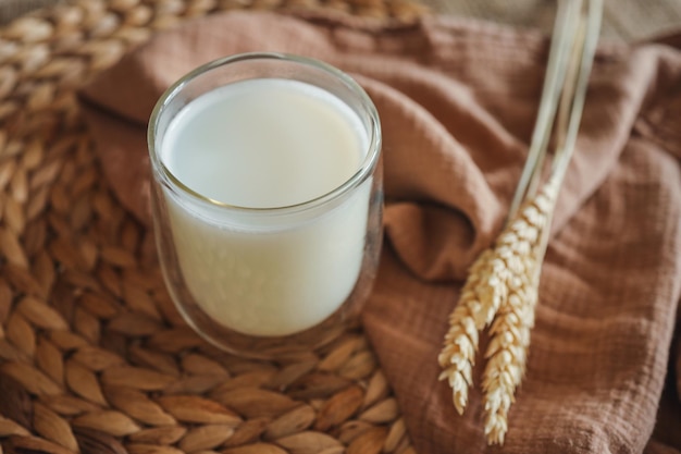 Glass of milk and ears of wheat close up