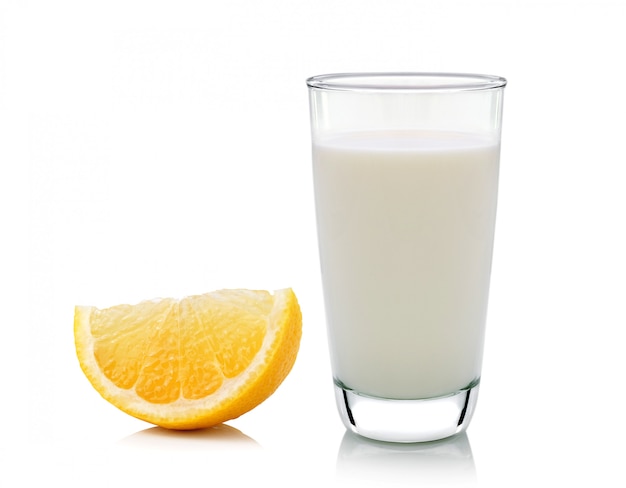 Стакан молока и половинного лимона на белом фоне, свежий и сочный