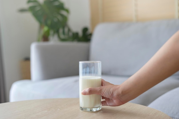 A glass of milk in modern living room with houseplant