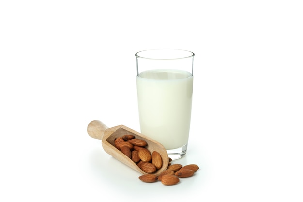 Glass of milk and nuts isolated on white