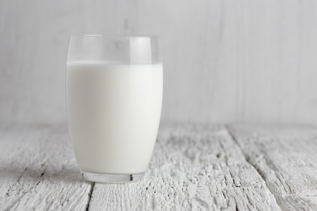 Glass of milk standing on old wooden table