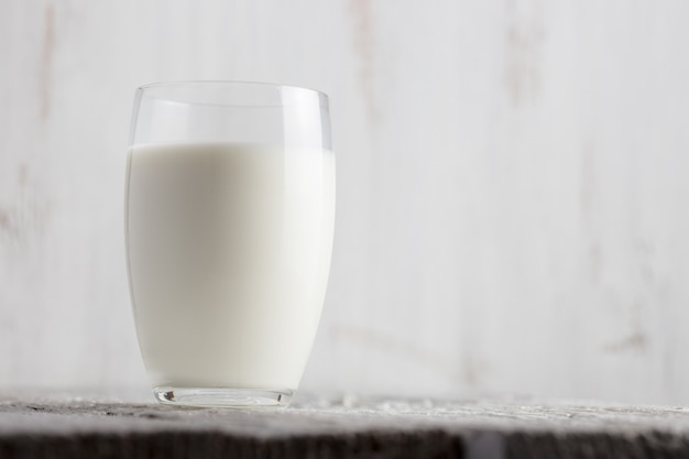 Glass of milk standing on old wooden table