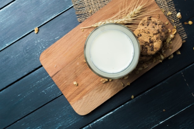 Glass of milk on table on blurred natural 